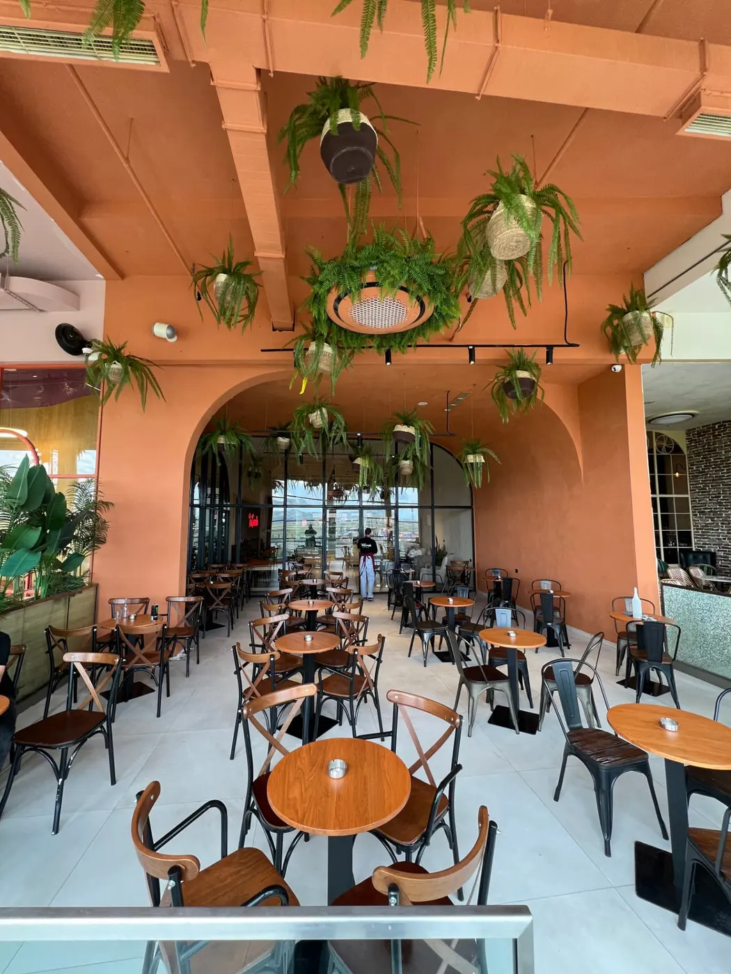 Tai Sweets Prishtina Mall dining room with terracotta walls and hanging ferns