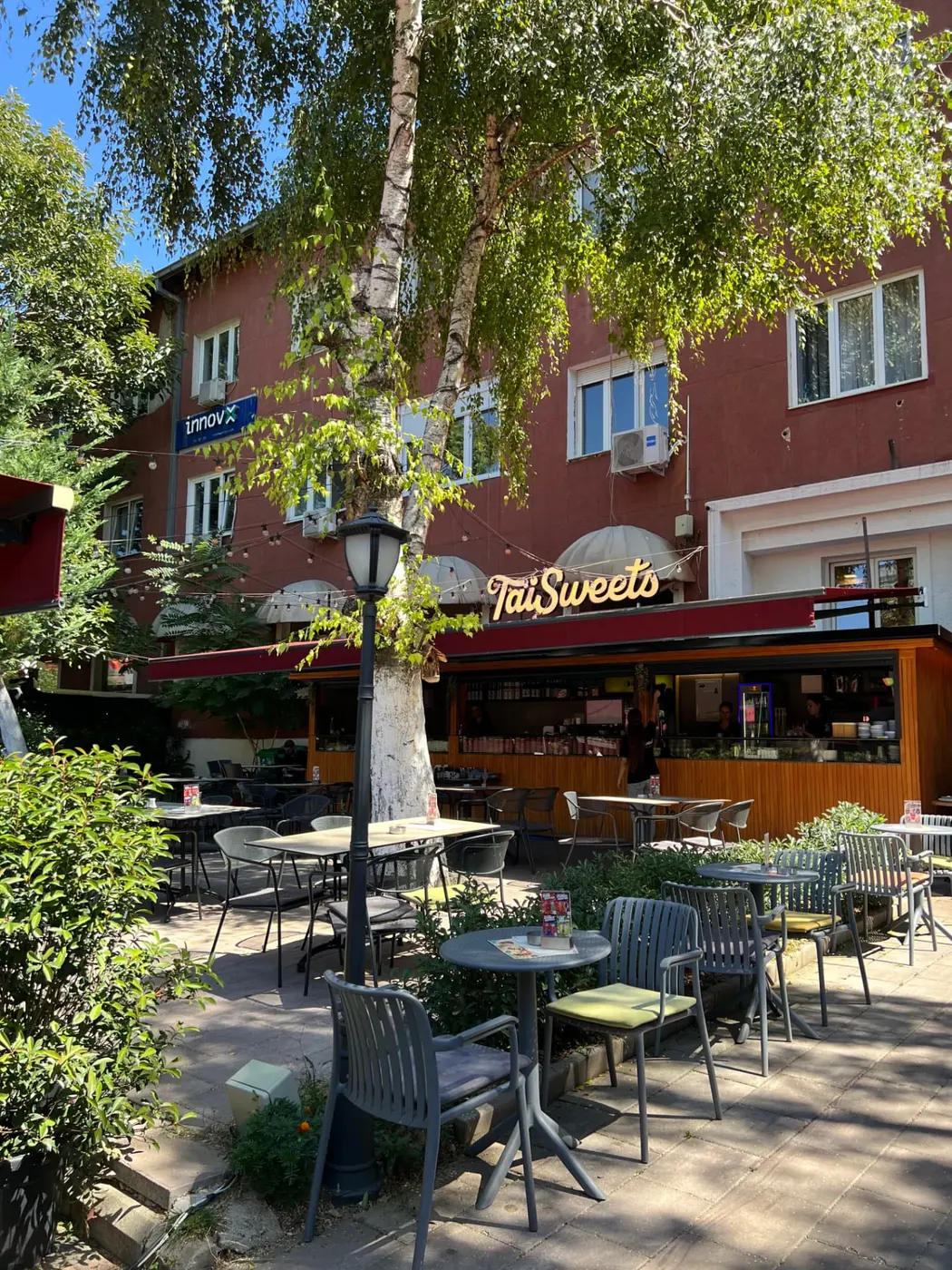 Tai Sweets terrace on Sheshi Nënë Tereza with the illuminated Tai Sweets sign